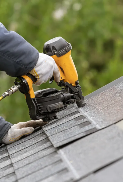 Roofer using a nail gun